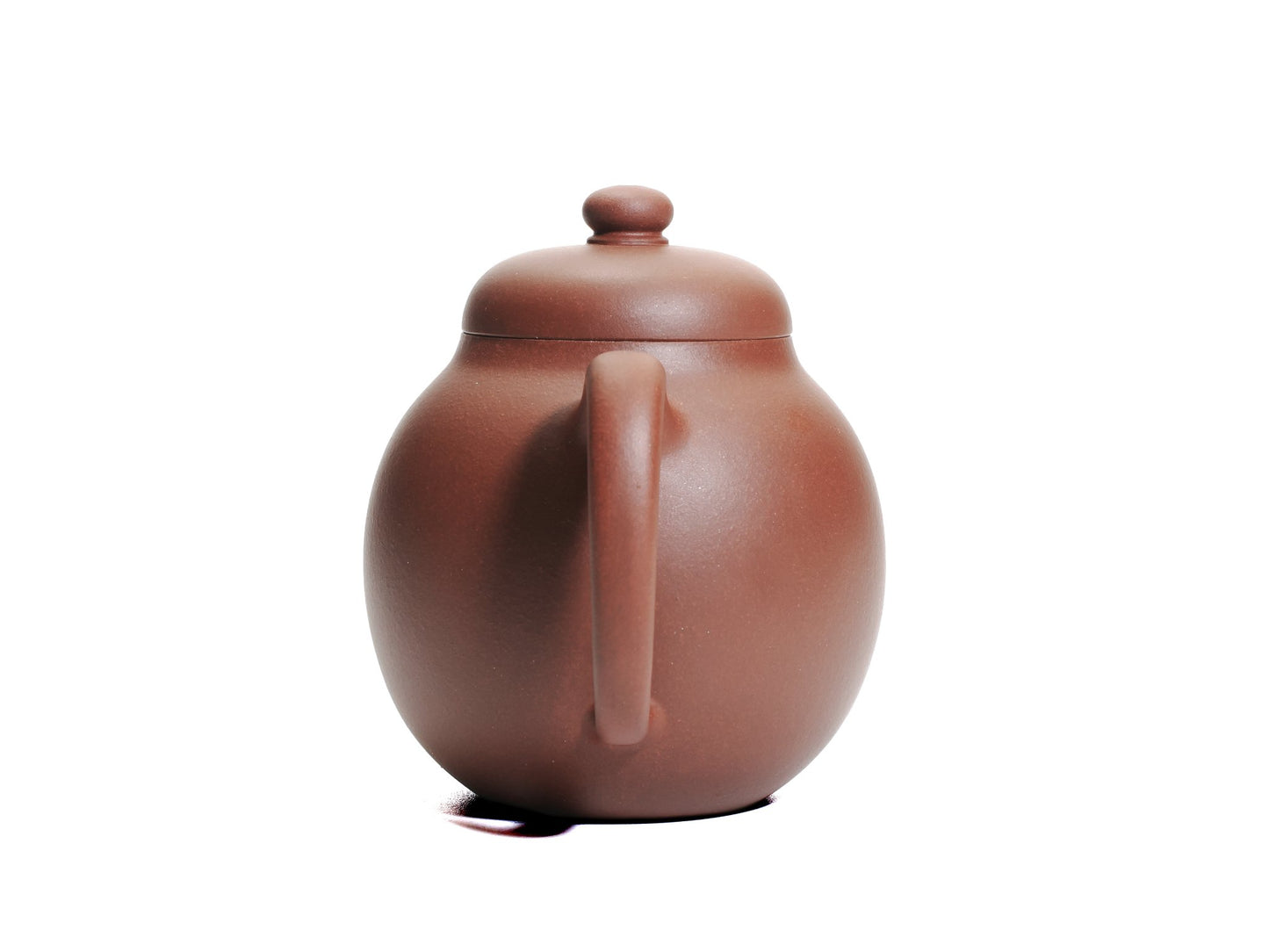 Back view of the Da Long Dan teapot focusing on the rounded handle and smooth red clay surface.