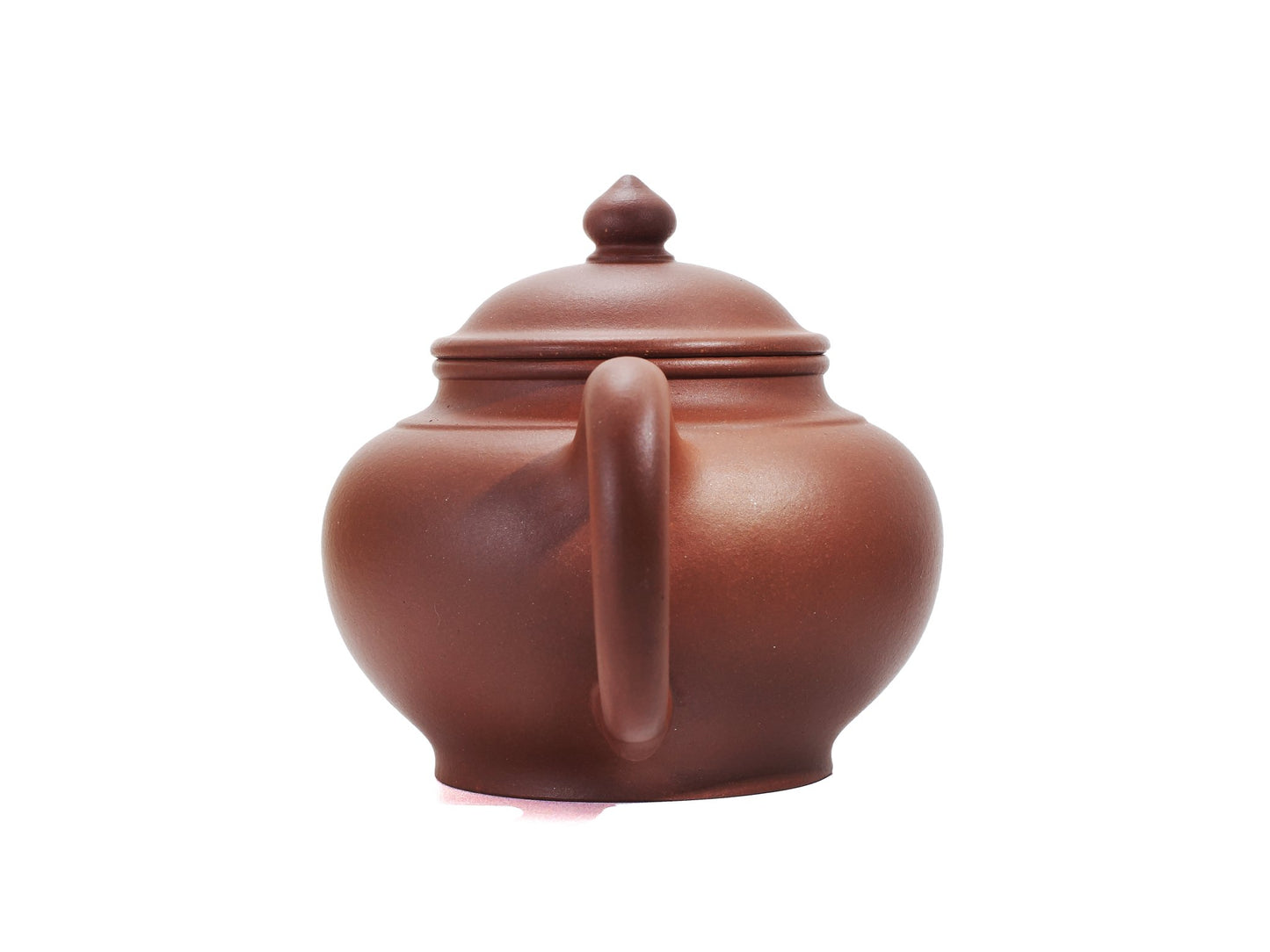Back view of the Zhao Zhuang Hong Ni Xiao Ying Hu teapot focusing on the rounded handle and the smooth red clay body.