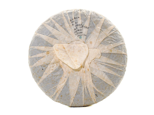 Back view of wrapped 2008 Wuliang Gushu Pu-erh Tea Cake showing traditional folded paper wrapping