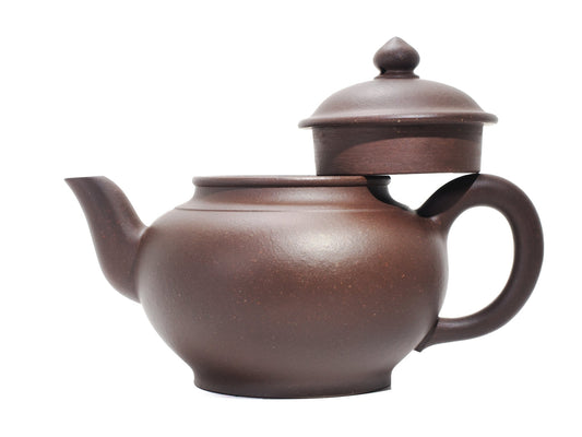 Side view of the Xiao Ying teapot with its lid removed and resting on the handle, highlighting the wide mouth opening and gentle spout curve.