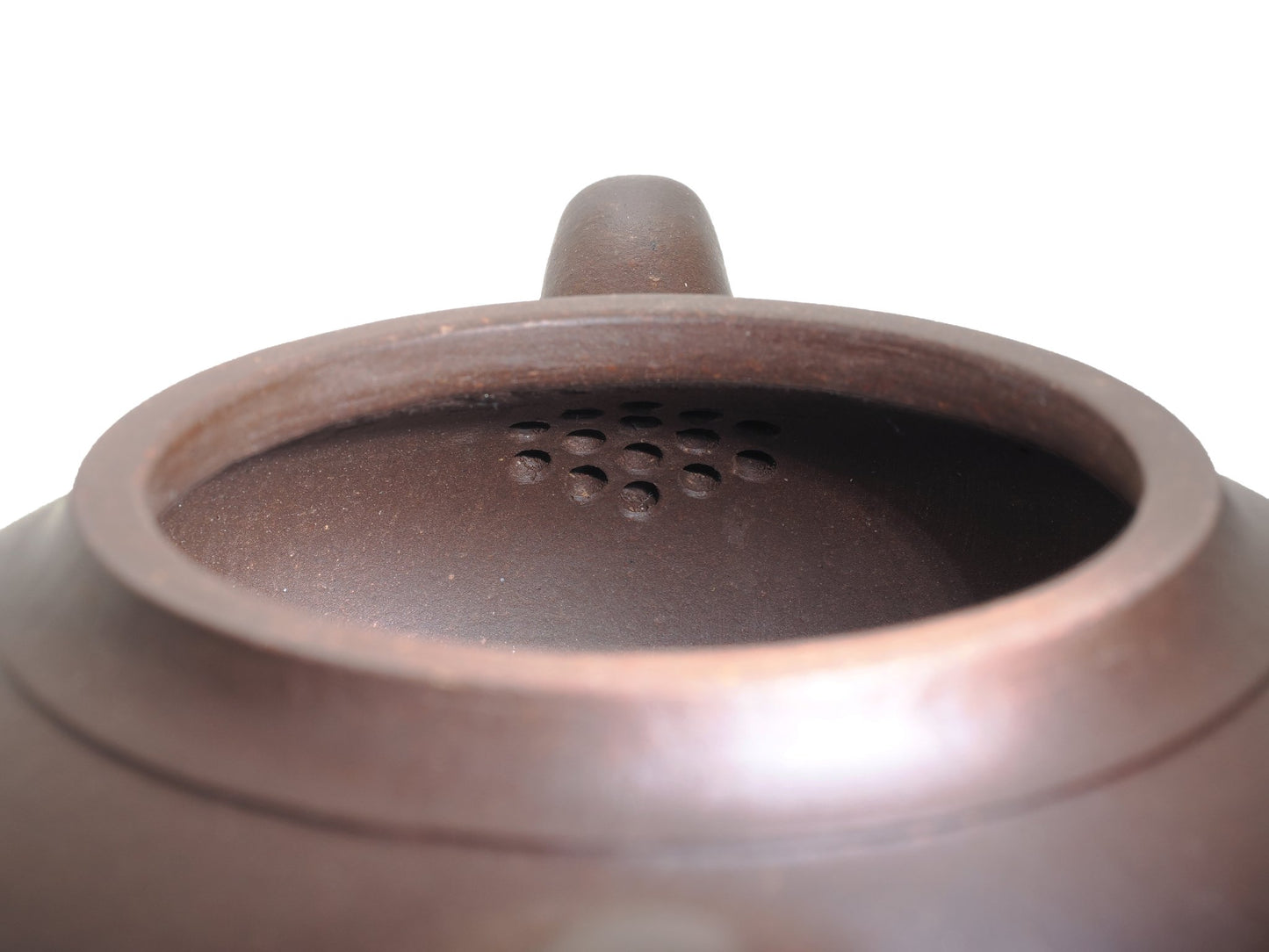 Close‑up of the teapot interior showing the built‑in multi‑hole filter that ensures a smooth pour without leaves.