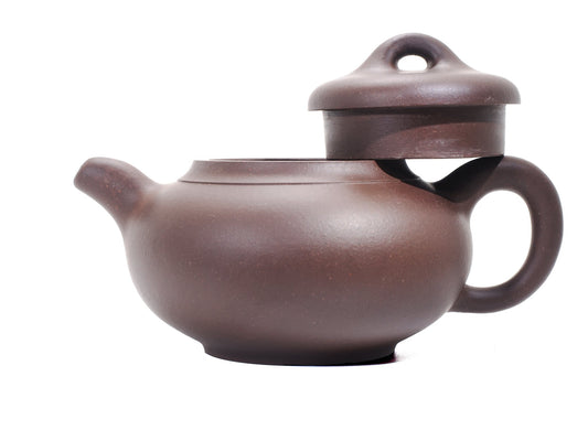 Side profile of the bronze‑grade Yun Tong Hu teapot with the lid removed and resting on the handle, highlighting the wide mouth and ring‑shaped knob.