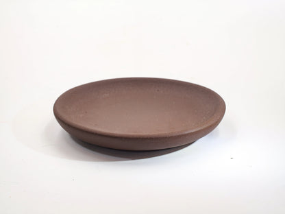 Cha Zhi Ji 30th Anniversary Bronze Grade Clay Dehou Coaster, showing the rustic matte texture and thick rim profile.