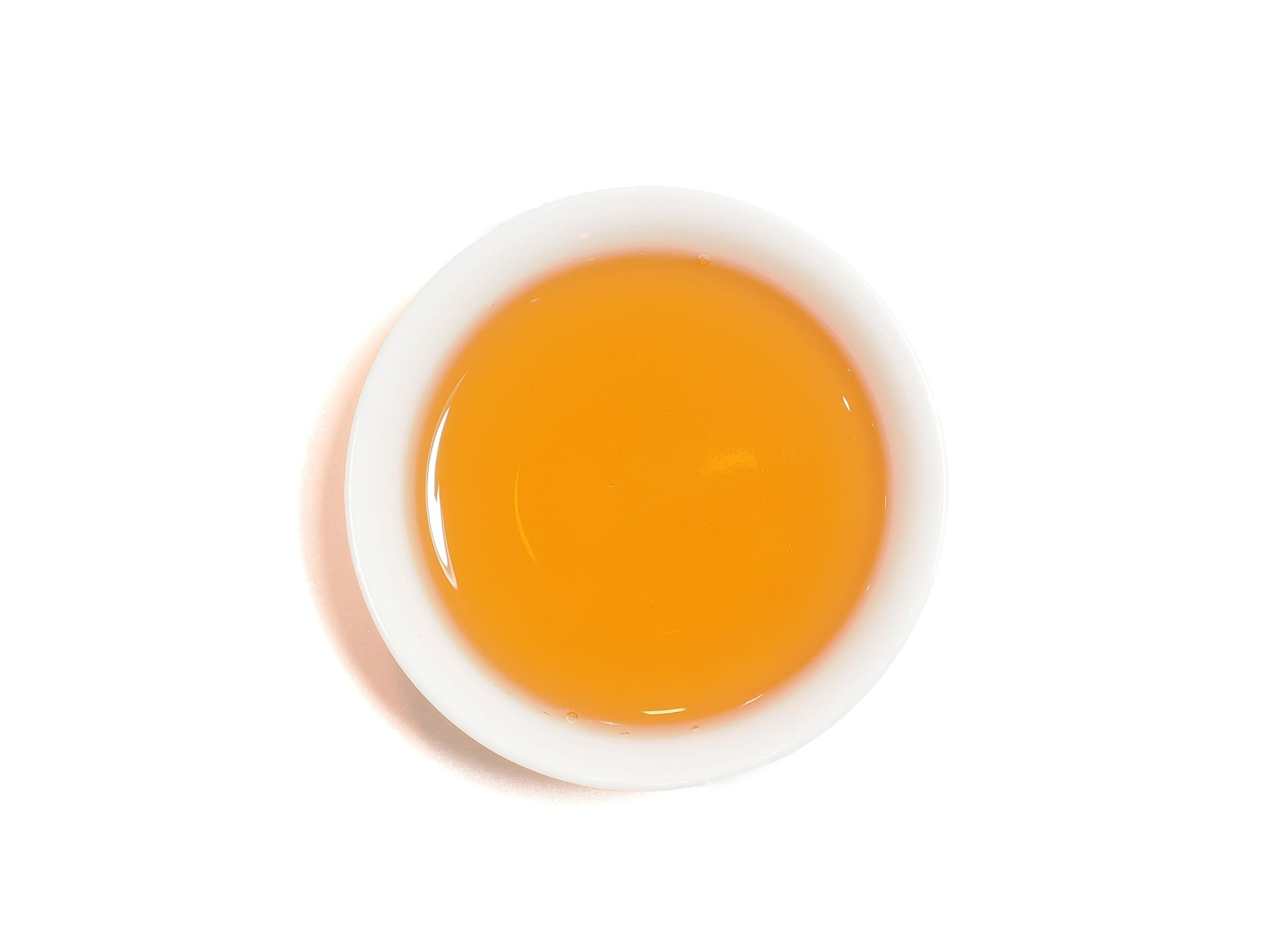 Bright orange-red liquor of Yixing Gong Hong black tea in a white cup